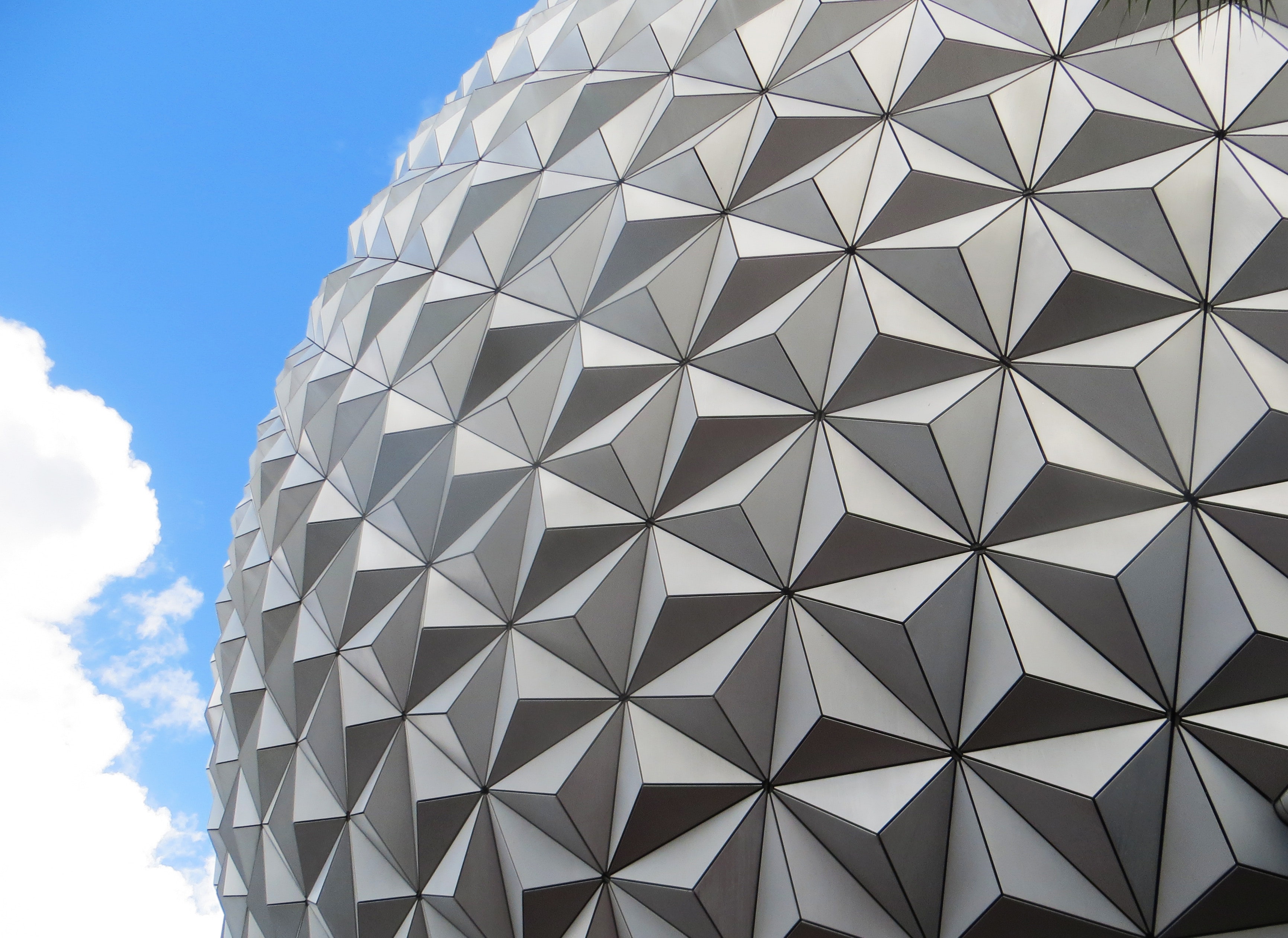 The image depicts the iconic white, geodesic sphere of Spaceship Earth, a prominent landmark at Epcot theme park, against ...